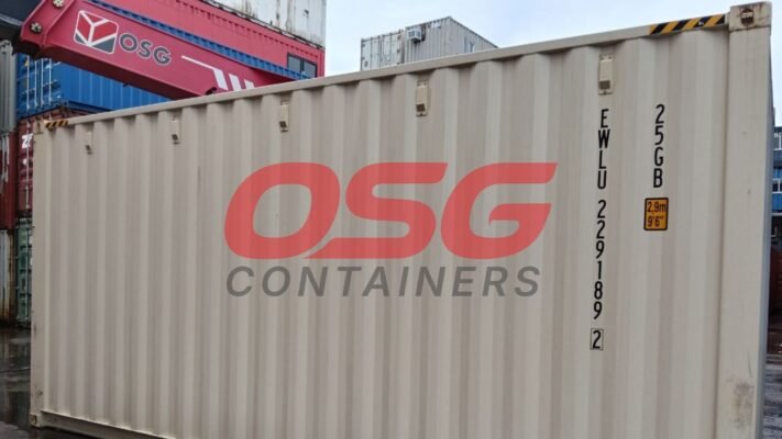 OSG containers stacked in a yard with a crane overhead.