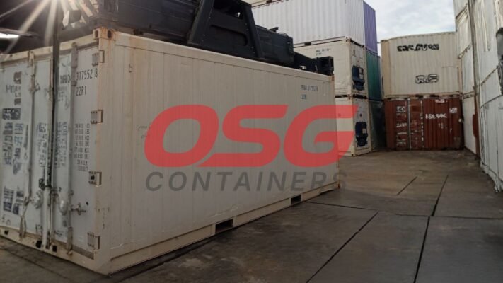 Stacked shipping containers at a port with a crane overhead.