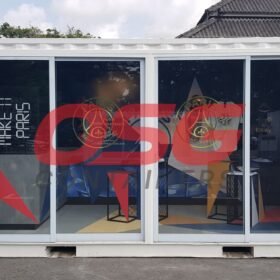 A white shipping container converted into a store with Paris Saint-Germain branding.
