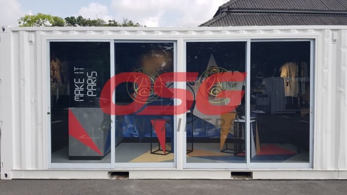 A white shipping container converted into a store with Paris Saint-Germain branding.
