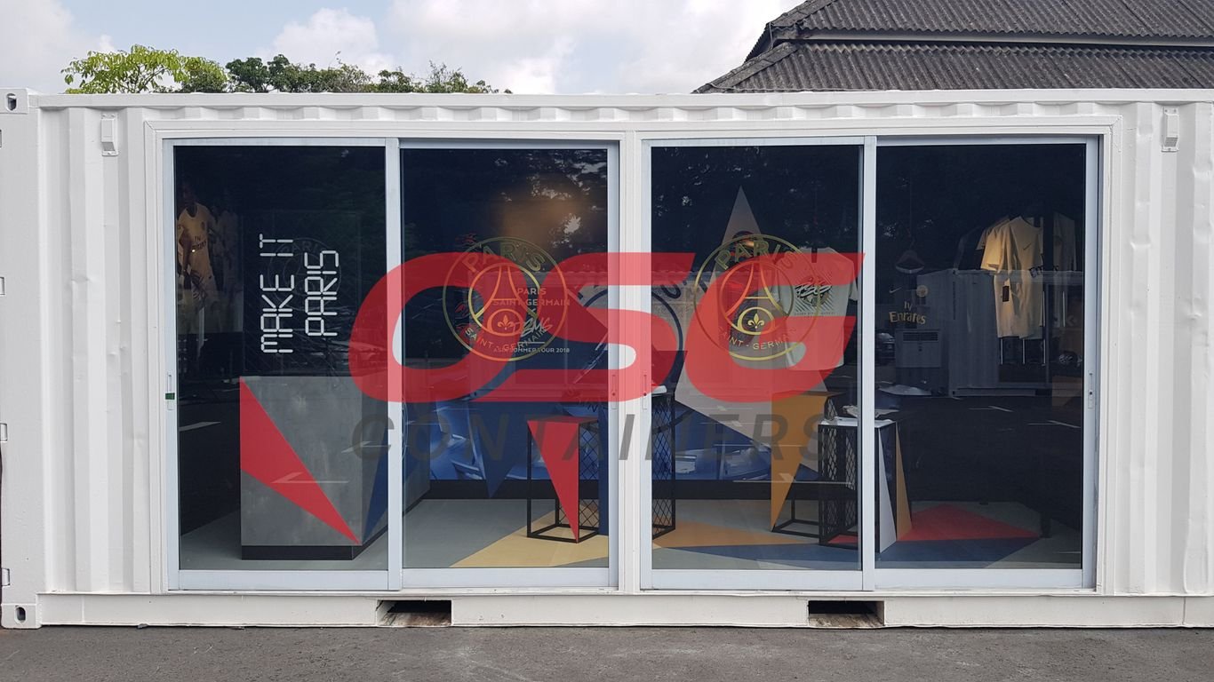 A white shipping container converted into a store with Paris Saint-Germain branding.