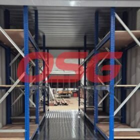 Interior of a shipping container with shelving units.