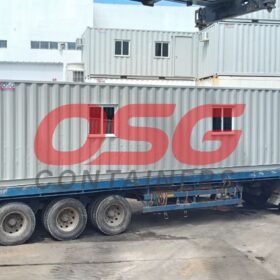 A long container is loaded onto a truck for transport.