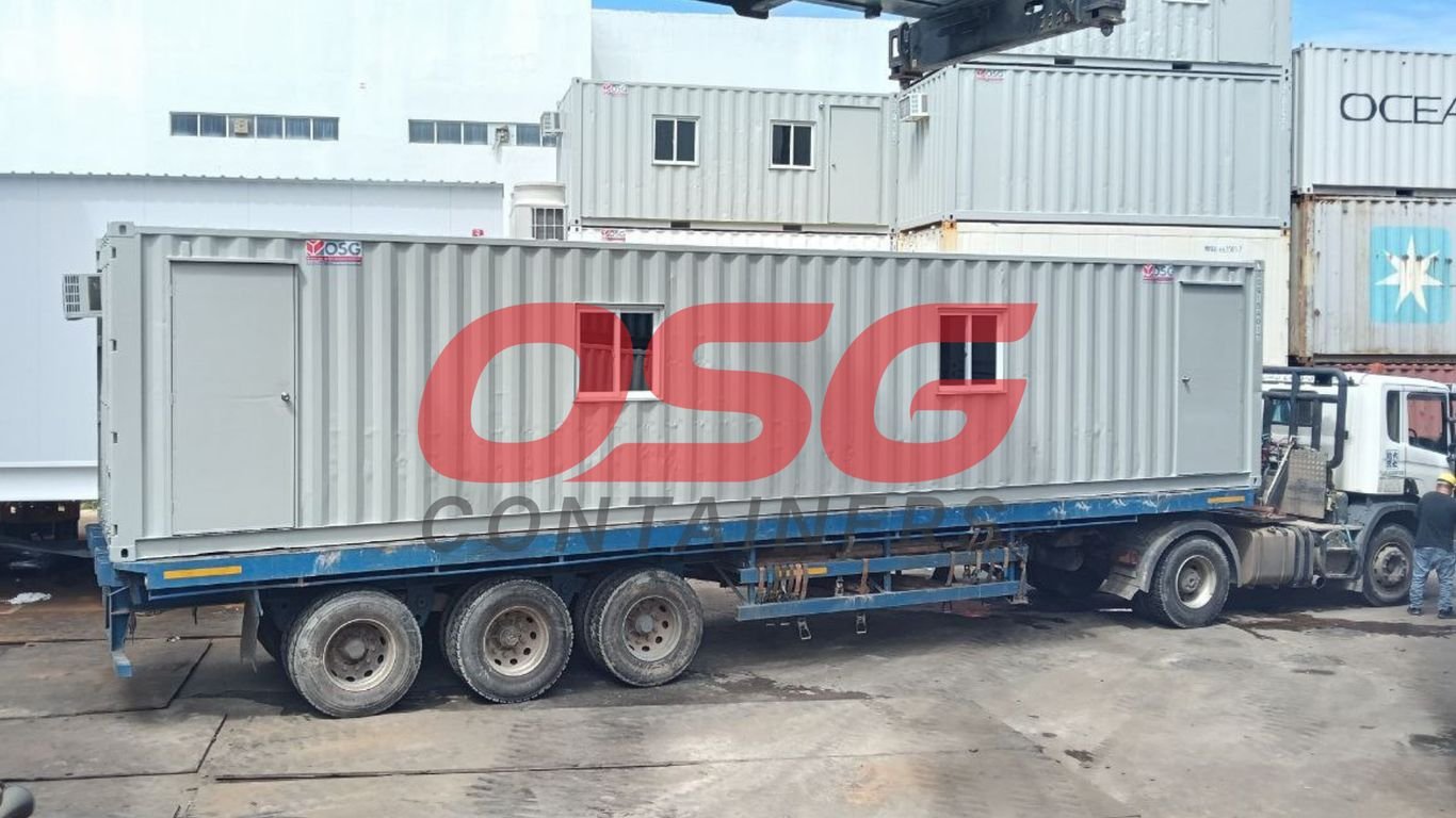 A long container is loaded onto a truck for transport.