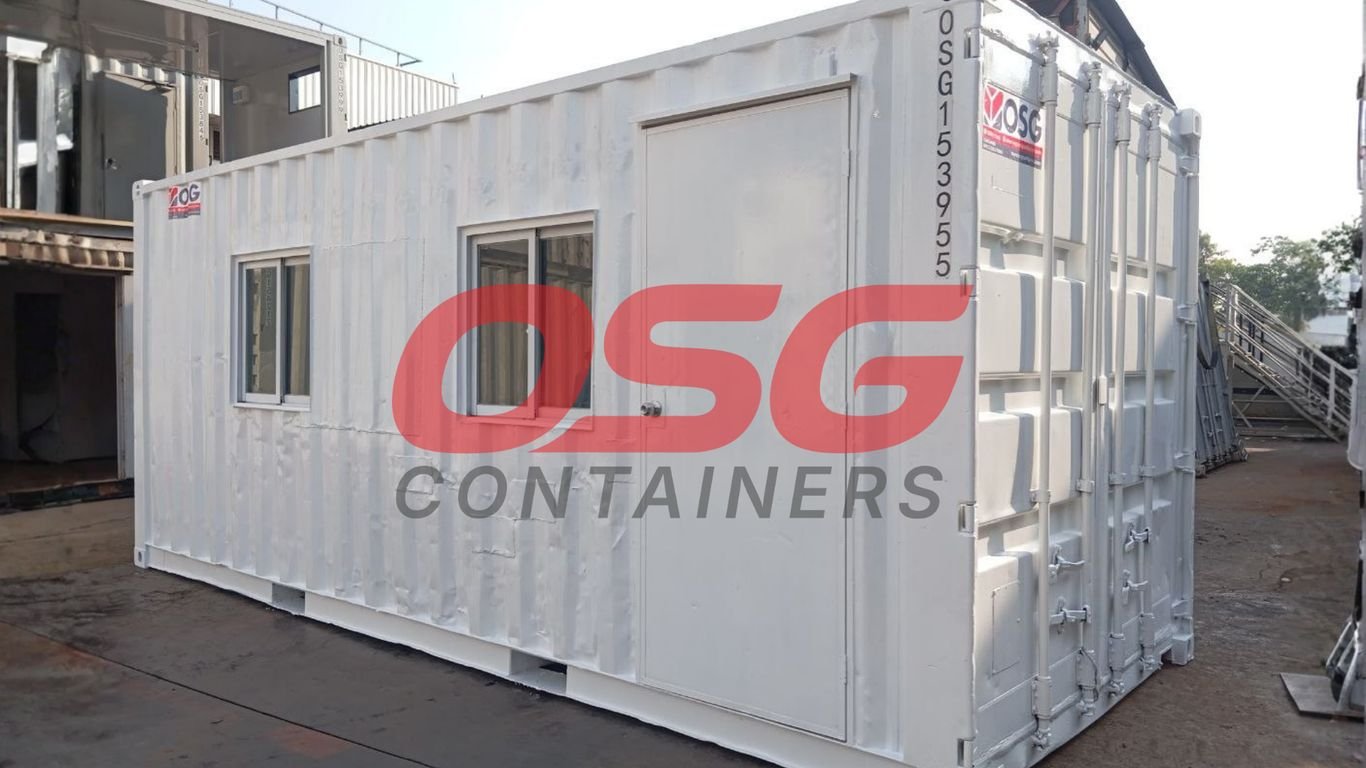 A white shipping container modified into a small office or room.