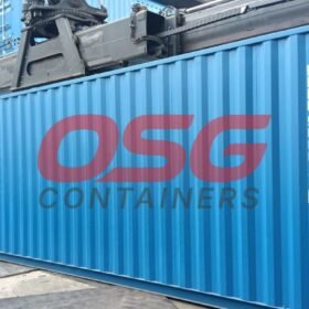 A blue shipping container with OSG Containers logo is being moved.