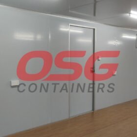 Interior of a modular container unit with doors and windows.