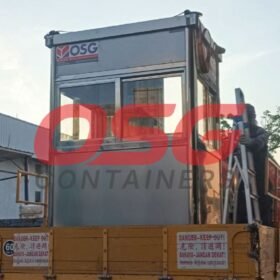 A portable guard house is loaded onto a truck.
