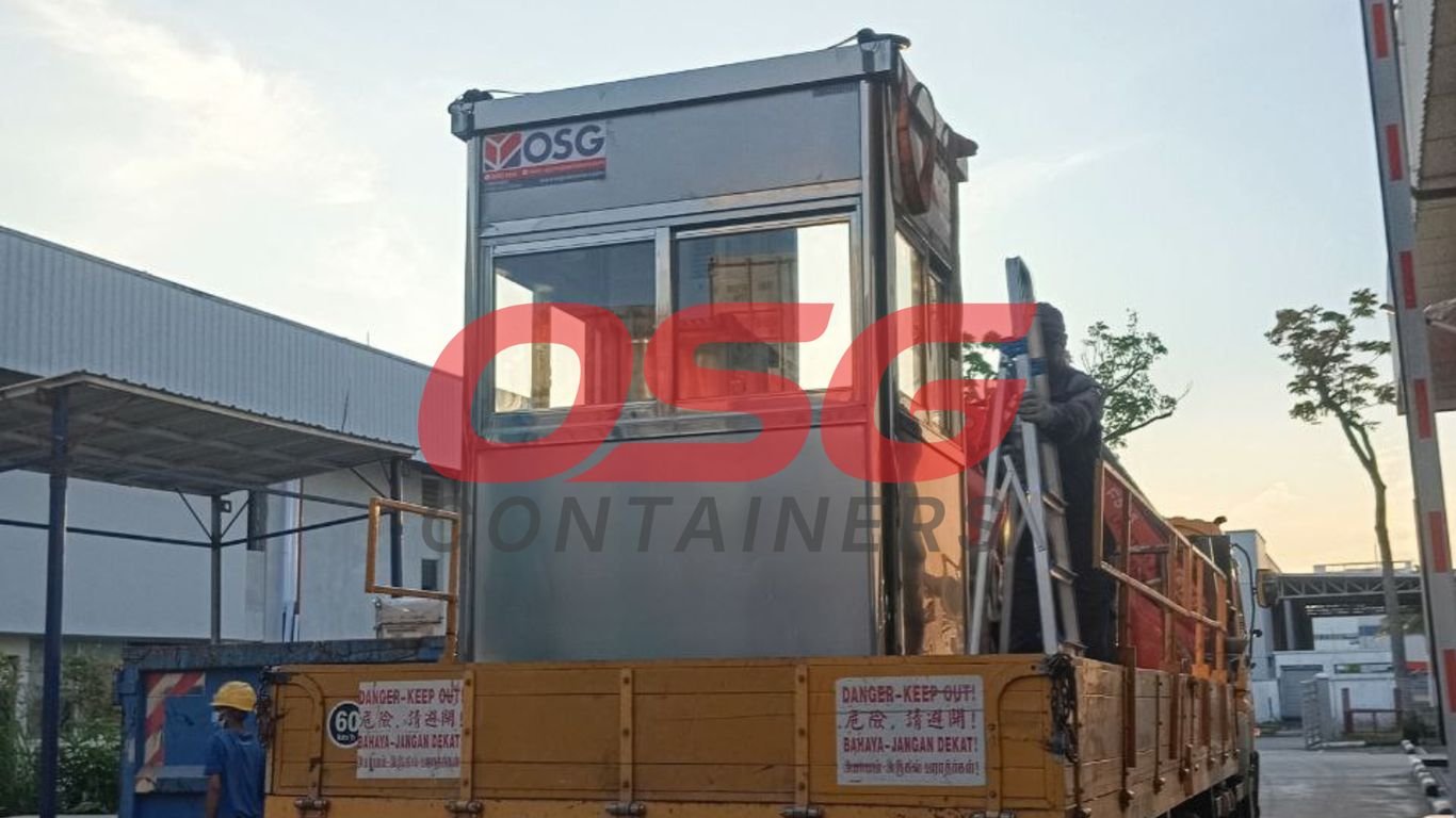 A portable guard house is loaded onto a truck.