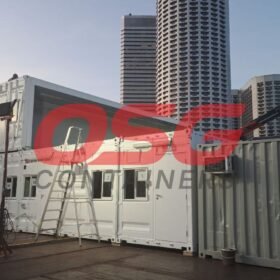 Modular container buildings stacked with a crane in the background.