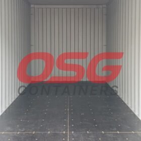 Inside of an empty shipping container with a logo on the wall.