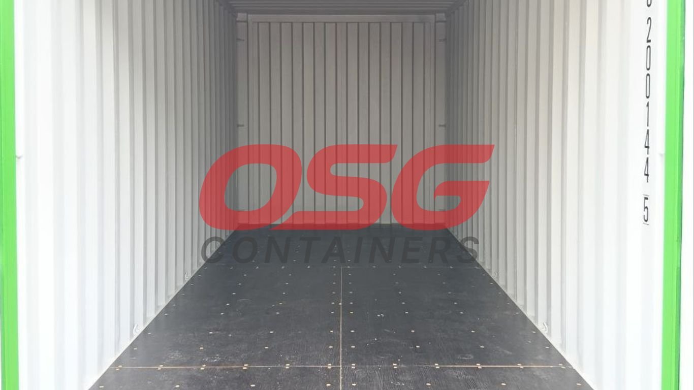 Inside of an empty shipping container with a logo on the wall.