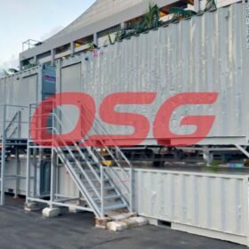 Stacked shipping containers with stairs and a large red OSG logo.