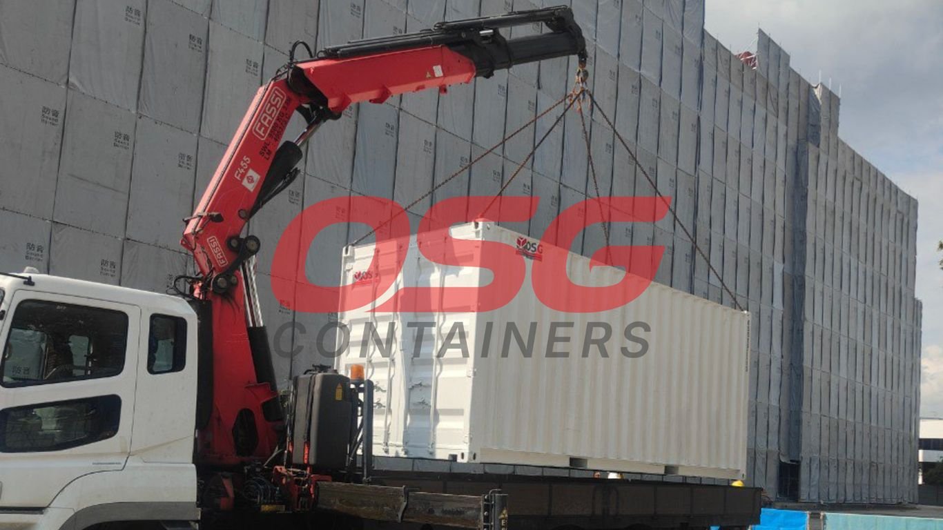 Crane lifting a shipping container onto a truck.