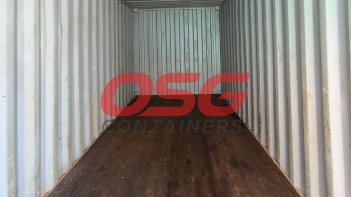 Inside of an empty shipping container with a wooden floor.