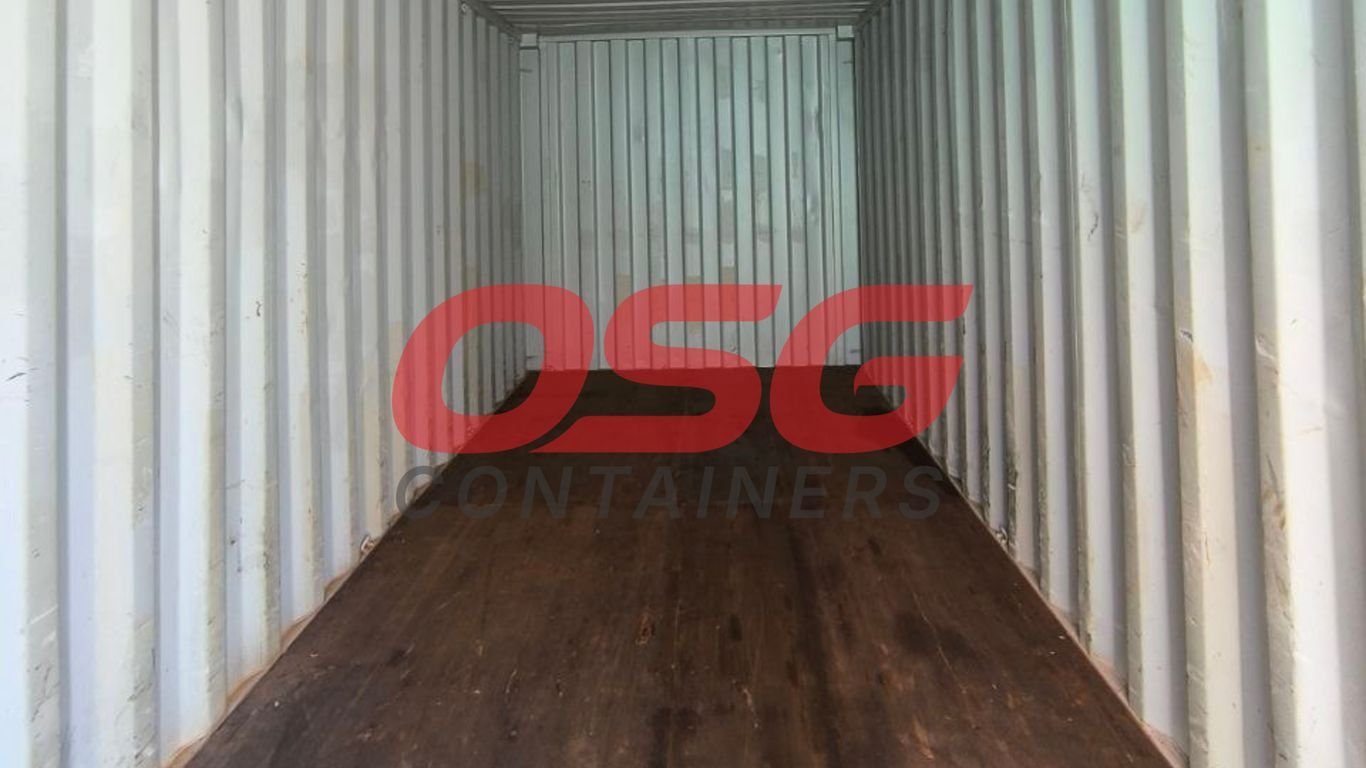 Inside of an empty shipping container with a wooden floor.