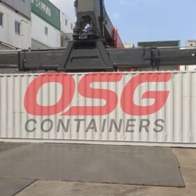 A crane lifts a white shipping container with OSG logo.