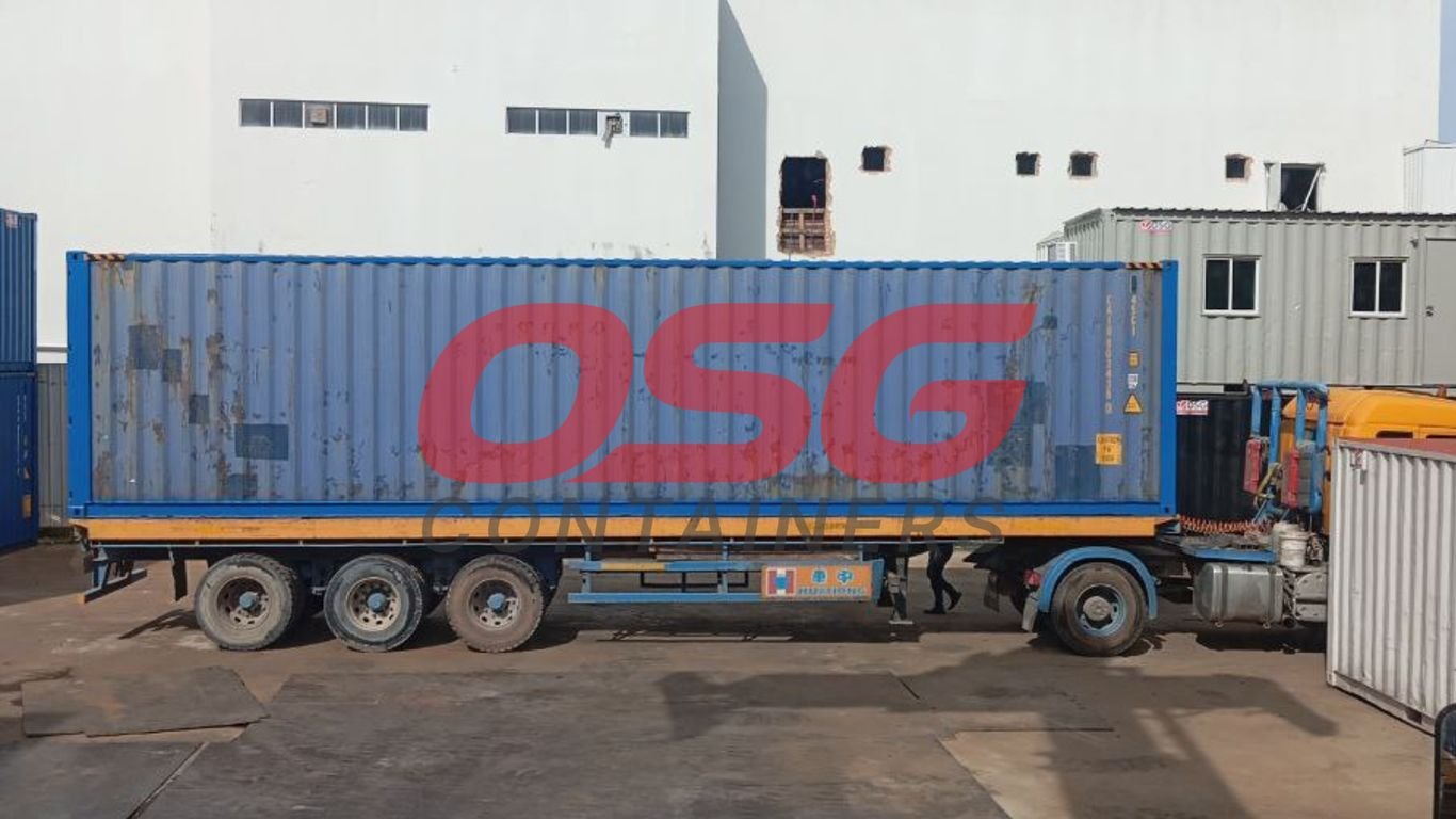 A blue shipping container on a truck with OSG logo.